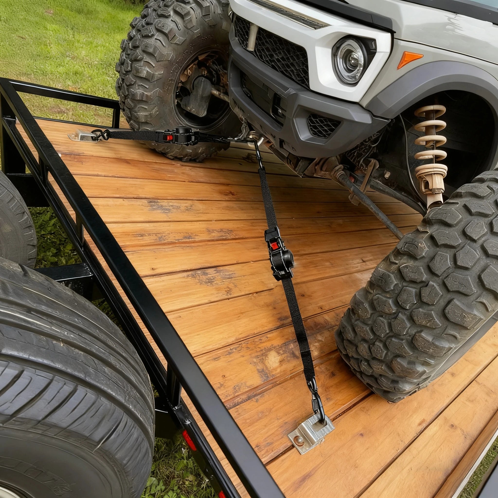 BOODAA Automatic retractable ratchet strap secures a small four-wheel off-road vehicle to a trailer